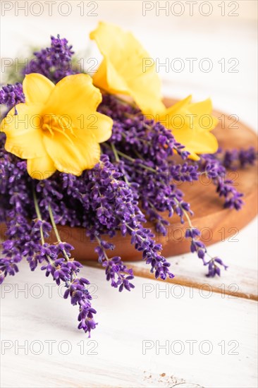 Beautiful day lily and lavender flowers on white wooden background, side view, close up, selective