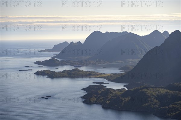 View of the coast in Ulvagsundet fjord and mountains in the evening light, Hurtigruten cruise ship