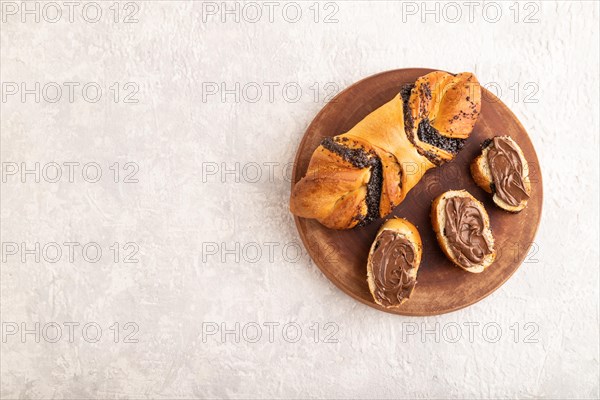 Homemade sweet bun with chocolate cream on a gray concrete background. top view, flat lay, copy