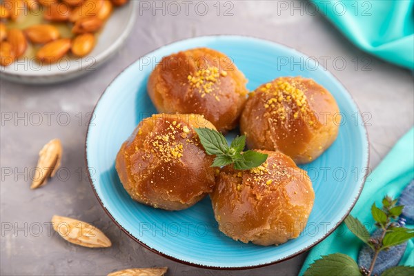 Homemade traditional turkish dessert sekerpare with almonds and honey, cup of green tea on gray