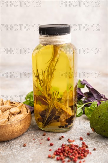 Sunflower oil in a glass jar with various herbs and spices, sesame, rosemary, avocado, basil,