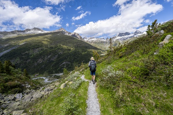 Mountaineers on a hiking trail in front of a picturesque mountain landscape, rocky mountain peaks
