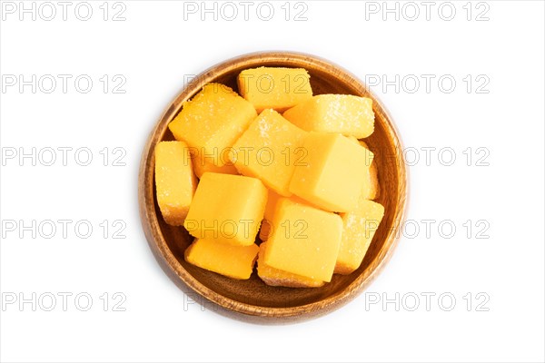 Dried and candied mango cubes in wooden bowls isolated on white background. Top view, flat lay,