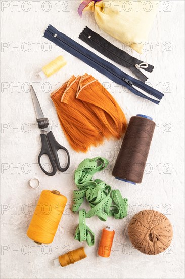 Sewing accessories: scissors, thread, thimbles, braid on gray concrete background. Top view, flat
