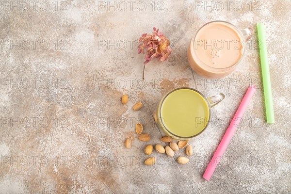 Bubble tea with pistachio and caramel in glass on brown concrete background. Healthy drink concept.