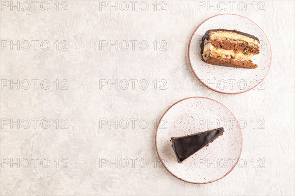 Chocolate biscuit cake with caramel cream and walnuts, on gray concrete background. top view, flat