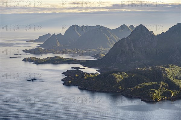 View of the coast in Ulvagsundet fjord and mountains in the evening light, Hurtigruten cruise ship