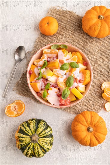 Vegetarian fruit salad of yogurt pumpkin, tangerine, pomegranate, grapefruit, basil microgreen