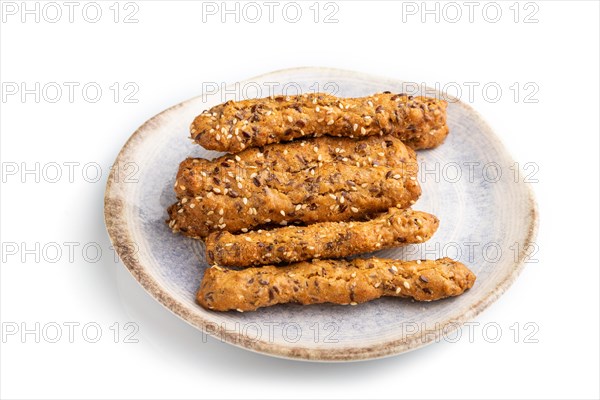 Crumble cookies with seasme and almonds on ceramic plate isolated on white background. side view,