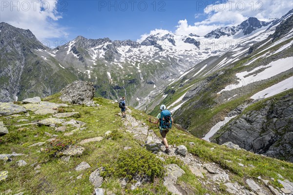 Mountaineer on hiking trail in picturesque mountain landscape, in the background mountain peak