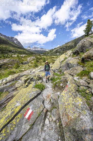 Mountaineers on a hiking trail in front of a picturesque mountain landscape, rocky mountain peaks
