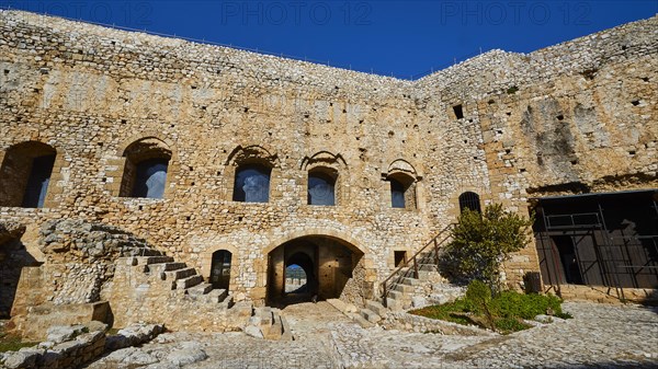 Inner courtyard of an old fortress with stone walls and arched windows, Chlemoutsi, High Medieval