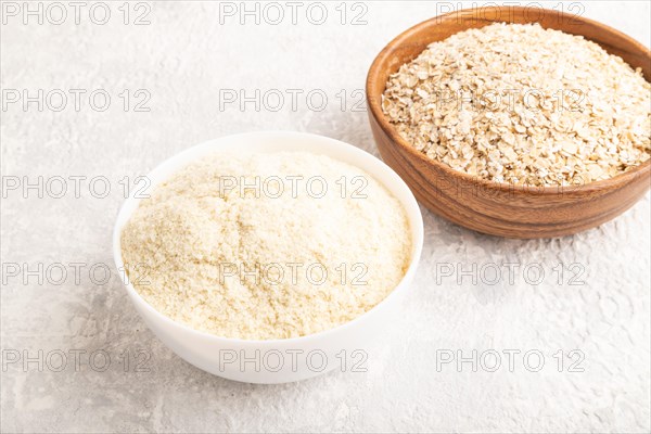 Powdered milk and oatmeal, baby food mix, infant formula on gray concrete background. Side view,
