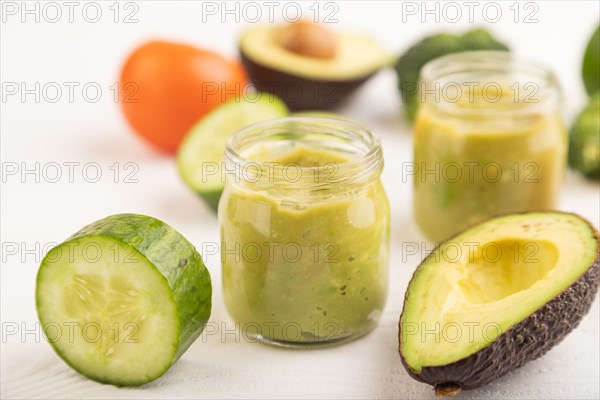 Baby puree with vegetable mix, broccoli, tomatoes, cucumber, avocado infant formula in glass jar on