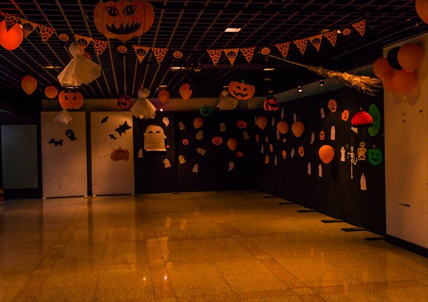 Dimly lit room decorated with hand made Halloween decorations of ghost, jack-o-lanterns and