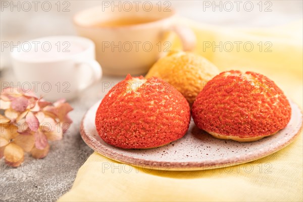 Traditional french custard dessert shu cake and cup of green tea on brown concrete background and