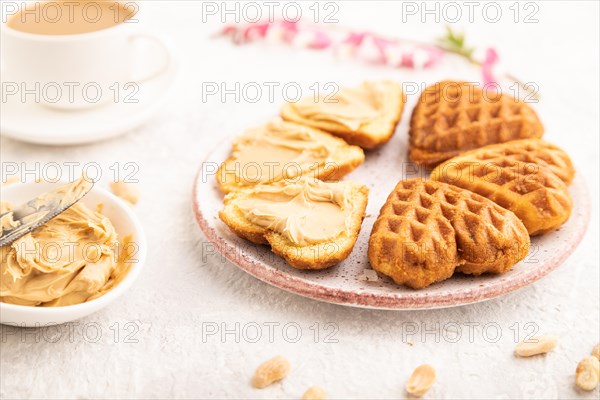 Homemade waffle with peanut butter and cup of coffee on a gray concrete background. side view,