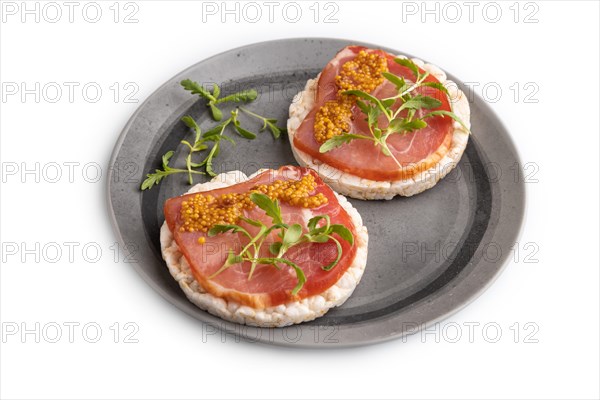 Puffed rice cake sandwiches with jerky salted meat, microgreen and mustard isolated on white