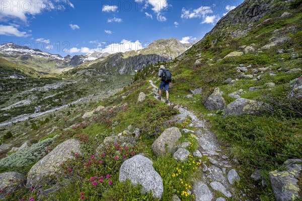 Mountaineers on a hiking trail in front of a picturesque mountain landscape, rocky mountain peaks