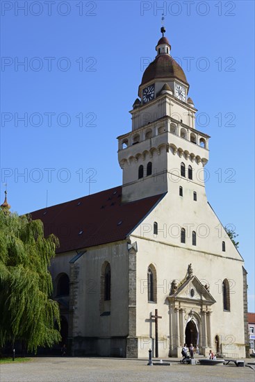 A sunny day illuminates a church with an onion dome and shade on the forecourt, Roman Catholic