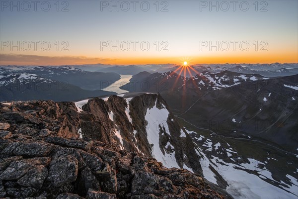 View of mountains and fjord Faleidfjorden, sun star at sunset, summit of Skala, Loen, Norway,