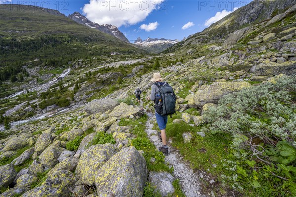 Mountaineers on a hiking trail in front of a picturesque mountain landscape, rocky mountain peaks