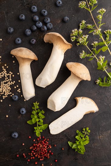King Oyster mushrooms or Eringi (Pleurotus eryngii) on black concrete background with blueberry,