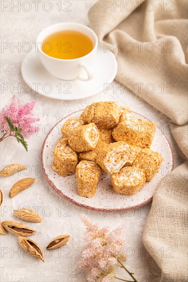 Traditional turkish delight (rahat lokum) with cup of green tea on a gray concrete background and