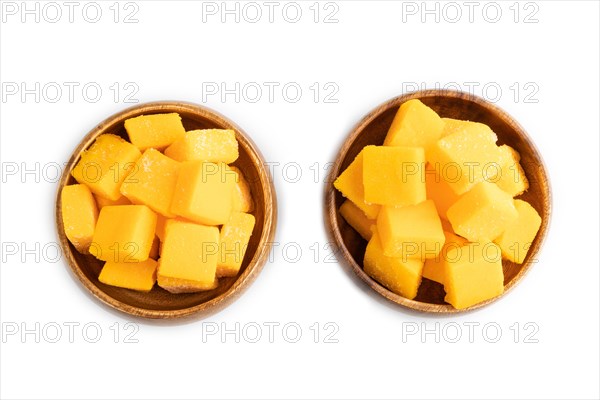 Dried and candied mango cubes in wooden bowls isolated on white background. Top view, flat lay,
