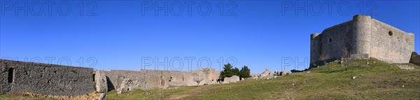Panoramic picture, Panoramic view of a historic fortress with long walls under a vast blue sky,