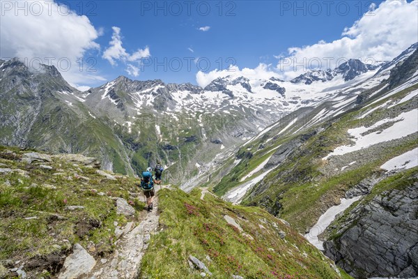 Mountaineer on hiking trail in picturesque mountain landscape, in the background mountain peak