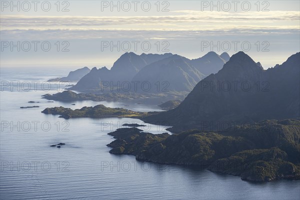 View of the coast in Ulvagsundet fjord and mountains in the evening light, view from the summit of