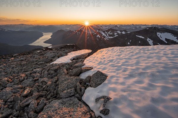 View of mountains and fjord Faleidfjorden, sun star at sunset, summit of Skala, Loen, Norway,