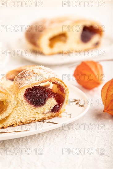 Homemade sweet bun with apricot jam and cup of coffee on gray concrete background. side view, close