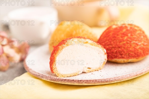 Traditional french custard dessert shu cake and cup of green tea on brown concrete background and
