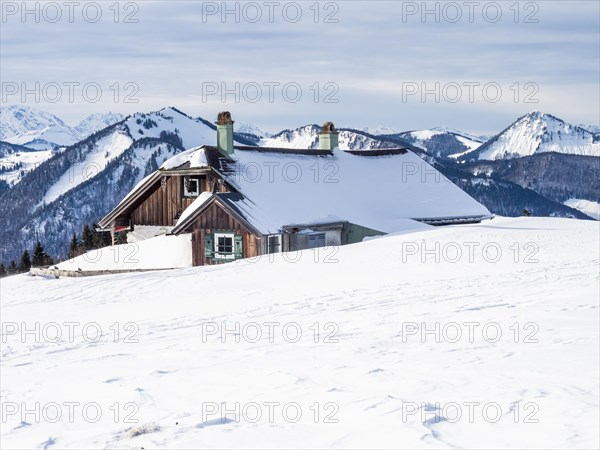 Winter atmosphere, snow-covered landscape, snow-covered alpine peaks, alpine hut on the