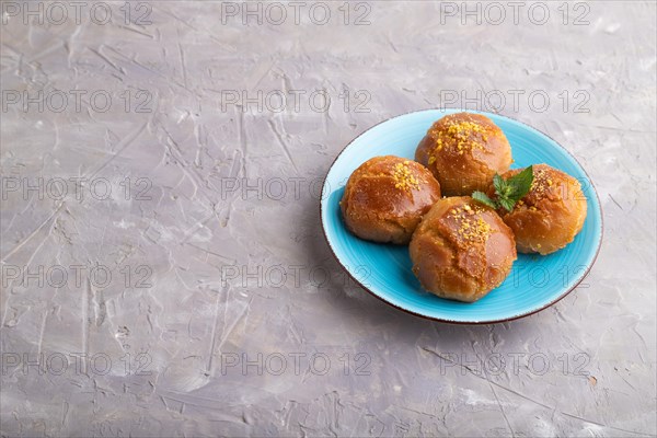 Homemade traditional turkish dessert sekerpare with almonds and honey on gray concrete background.
