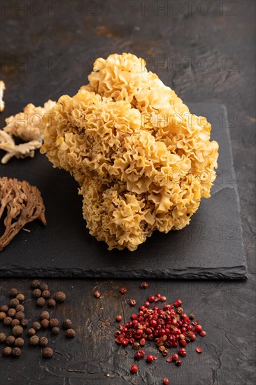 Raw Sparassis (Cauliflower Mushroom), Hericium, Clavaria (coral mushroom) on black concrete