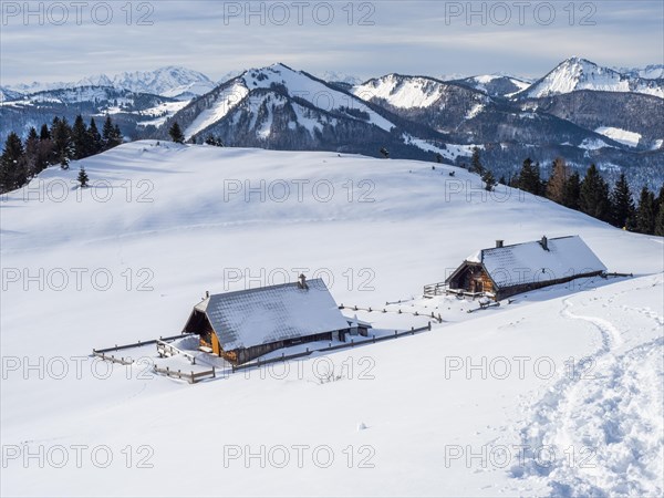 Winter atmosphere, snow-covered landscape, snow-covered alpine peaks, alpine huts on the