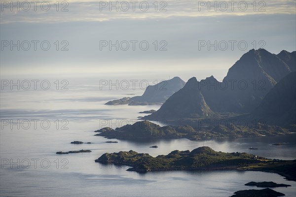 View of the coast in Ulvagsundet fjord and mountains in the evening light, Hurtigruten cruise ship