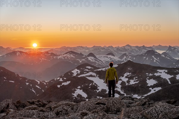 Mountaineer enjoying the view, mountain panorama at the summit of Skala at sunset, sun setting