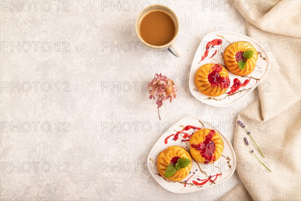 Semolina cheesecake with strawberry jam, lavender, cup of coffee on gray concrete background and