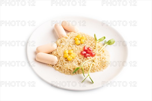 Funny mixed quinoa porridge, sweet corn, pomegranate seeds and small sausages in form of cat face