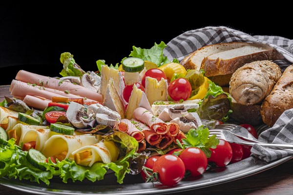 A selection of cheeses and vegan sausages with pastries, vegetables and salad, appetisingly