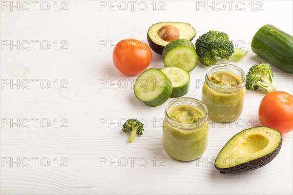 Baby puree with vegetable mix, broccoli, tomatoes, cucumber, avocado infant formula in glass jar on
