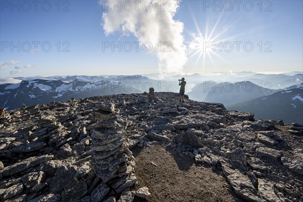 Mountaineers photographed, at the summit of Skala with cairns, view of mountain landscape and fjord