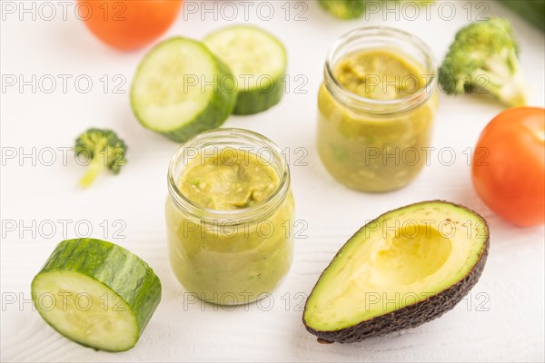 Baby puree with vegetable mix, broccoli, tomatoes, cucumber, avocado infant formula in glass jar on