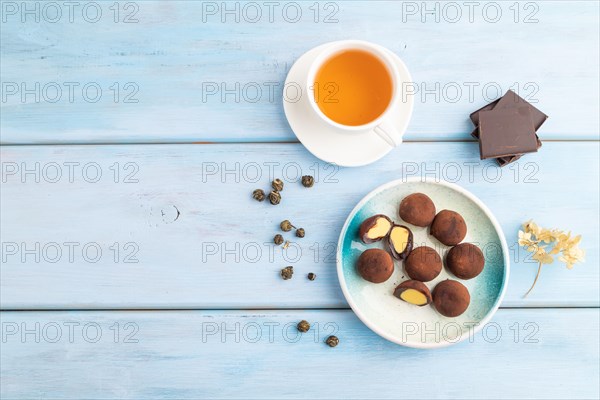 Japanese rice sweet buns chocolate mochi filled with cream and cup of green tea on blue wooden