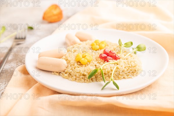 Funny mixed quinoa porridge, sweet corn, pomegranate seeds and small sausages in form of cat face