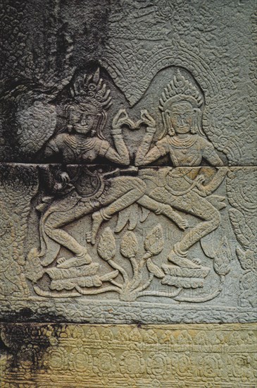 Bas-relief of Apsaras, celestial dancers from Hindu mythology, carved in stone in Khmer style.